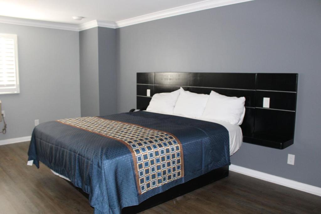 A hotel room with a large bed, blue bedspread, and white pillows.